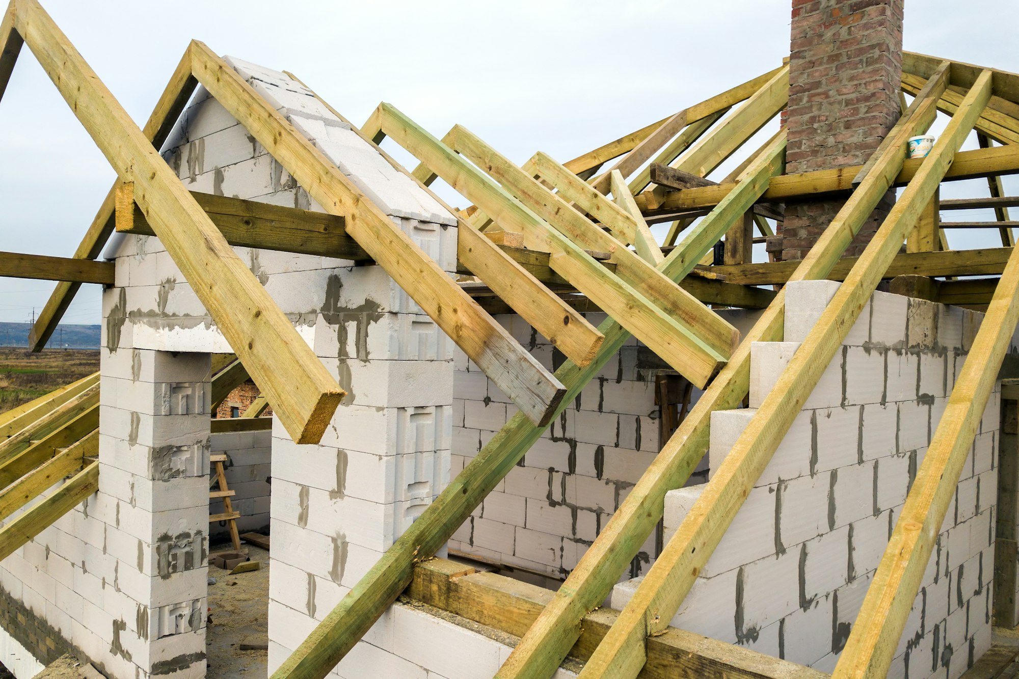 Aerial view of a private house with aerated concrete brick walls and wooden frame for future roof.