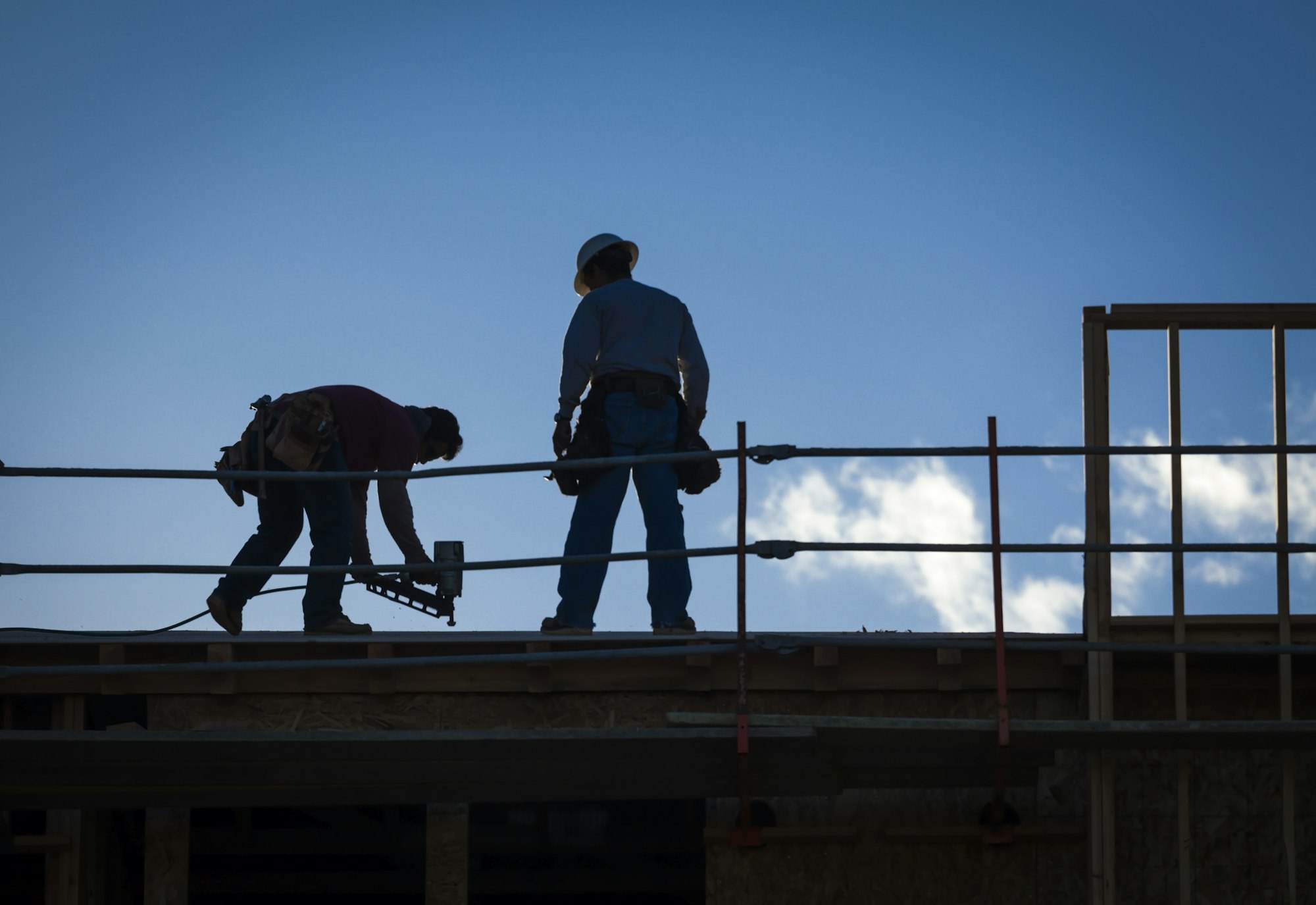 Construction Workers Silhouette on Roof