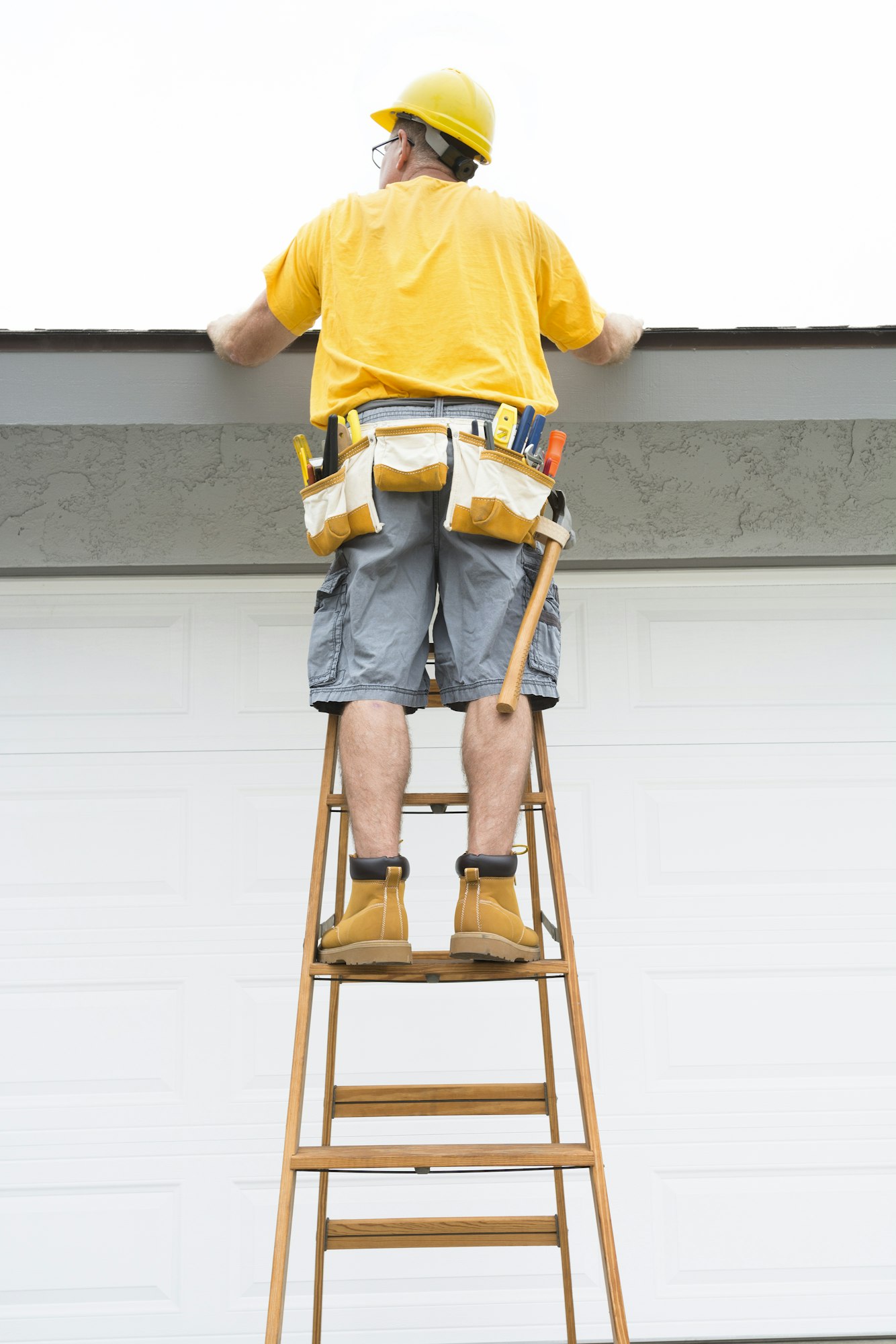 Contractor standing on ladder