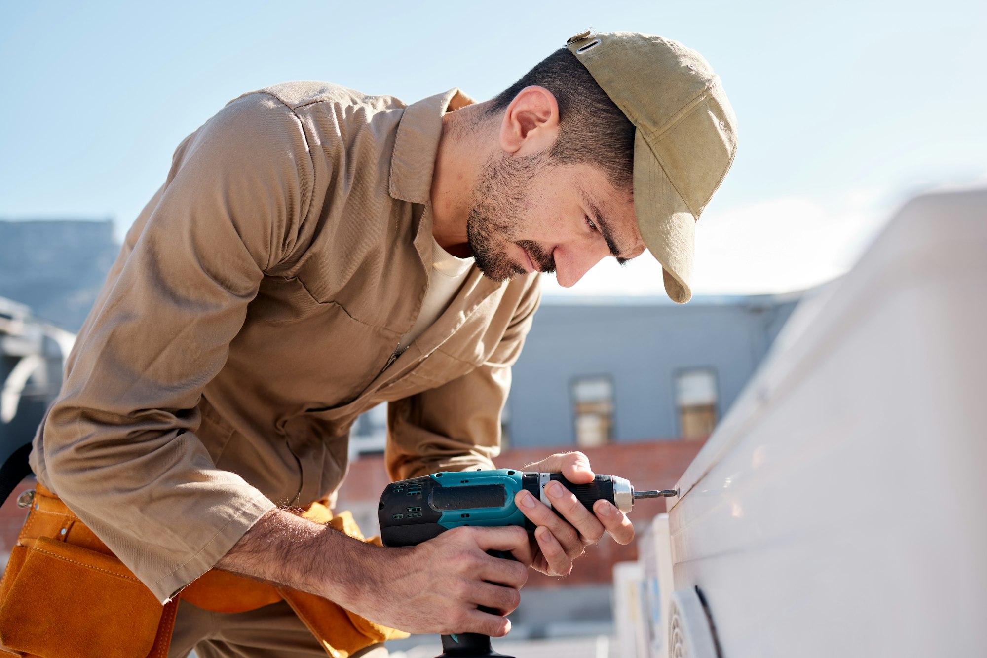 Technician man, drill and outdoor with air conditioner maintenance, roof or building in metro cbd f